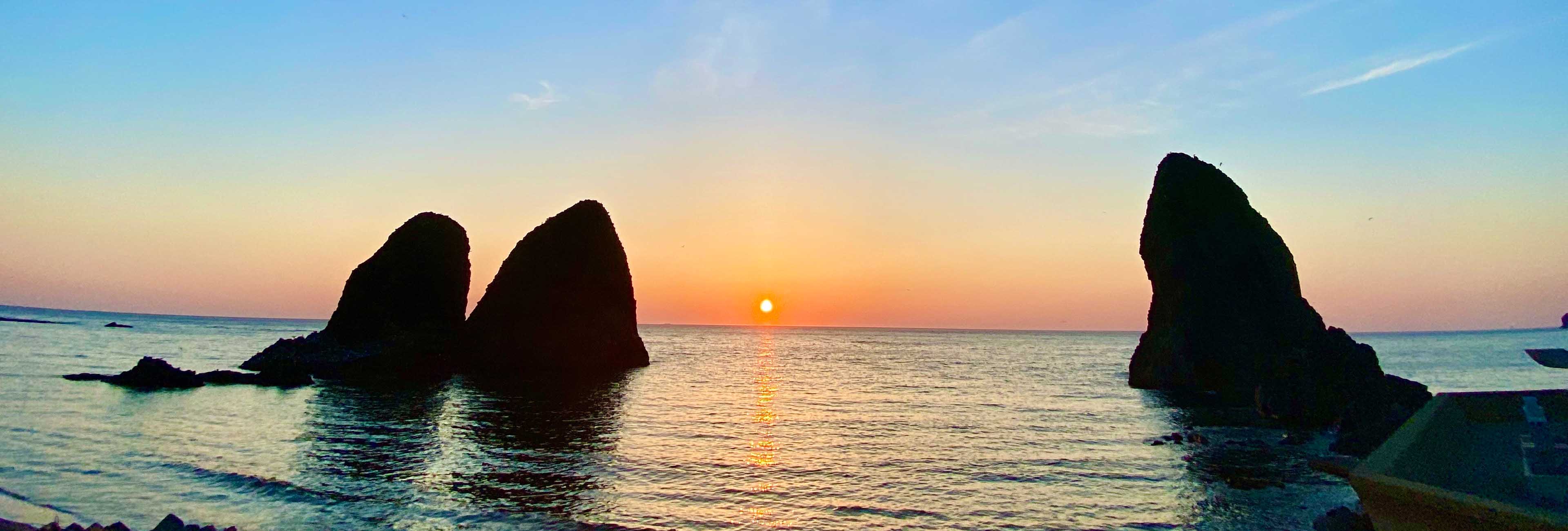 日本海に沈む夕陽の三本杉岩